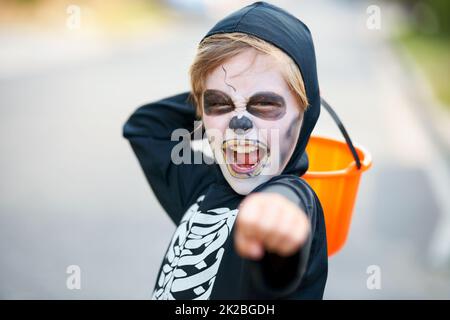 Trick or Treat. Kleiner Junge, der als Skelett an Halloween verkleidet ist und versucht, dich zu beschißen. Stockfoto