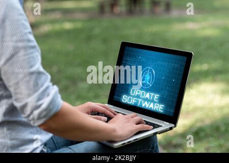 Textüberschrift zur Darstellung der Update-Software. Geschäftsübersicht ein Anwendungs-Patch behebt die zuvor gefundenen Bugs Frau, die mit LATOP allein im Park sitzt und Remote-Jobs durchführt. Stockfoto