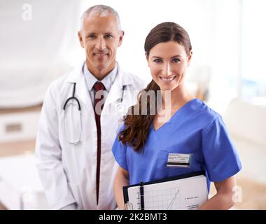 Ihr lächelndes OP-Team. Porträt von zwei freundlichen Ärzten. Stockfoto