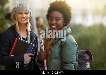 Waren auf dem Weg zur Klasse. Beschnittenes Porträt von zwei Studenten auf dem Campus. Stockfoto