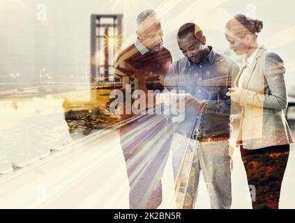 Die Stadt durch Teamarbeit mitführen. Eine kurze Aufnahme von drei Geschäftsleuten, die über einer Stadt überlagert wurden. Stockfoto