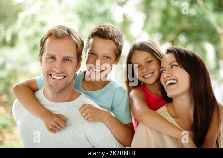 Gemeinsam schöne Erinnerungen sammeln. Porträt einer glücklichen vierköpfigen Familie, die Zeit im Freien verbringt. Stockfoto