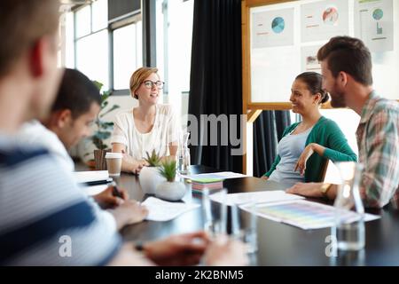 Sie alle haben ihre eigenen Ideen. Eine kurze Aufnahme junger Designer, die in ihrem Büro zusammenarbeiten. Stockfoto