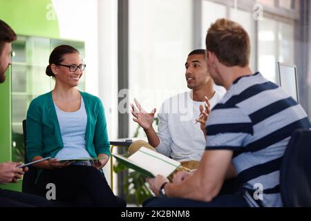 Sie alle haben ihre eigenen Ideen. Eine kurze Aufnahme junger Designer, die in ihrem Büro zusammenarbeiten. Stockfoto