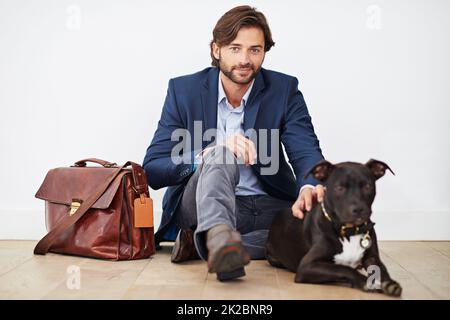 Glück kommt zu deinem Hund nach Hause. Aufnahme eines hübschen Mannes, der nach einem Tag im Büro Zeit mit seinem Hund verbringt. Stockfoto