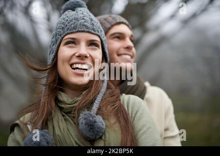 Sie lieben es, die Aussicht auf die Berge zu genießen. Ein glückliches junges Paar genießt die Sehenswürdigkeiten beim Wandern durch den Berg. Stockfoto