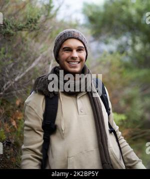 Er liebt es, mit der Natur in Berührung zu kommen. Porträt eines hübschen jungen Mannes, der in den Bergen unterwegs ist. Stockfoto