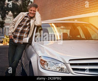 Mein neues Baby und shes alle meine. Porträt eines glücklichen, reifen Mannes, der sich an seinem Auto lehnt. Stockfoto