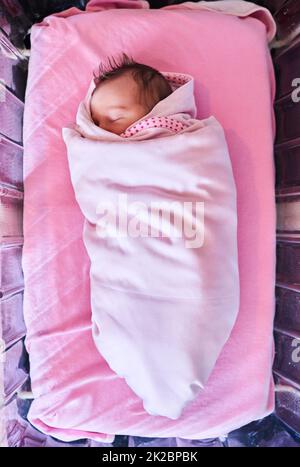 Süße Träume kleiner. High-Angle-Aufnahme eines neugeborenen Mädchens, das in eine Decke im Krankenhaus gehüllt ist. Stockfoto