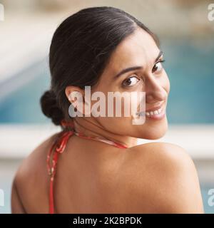 Der beste Weg, um einen heißen Nachmittag zu verbringen. Aufnahme einer jungen Frau, die sich am Pool entspannt. Stockfoto