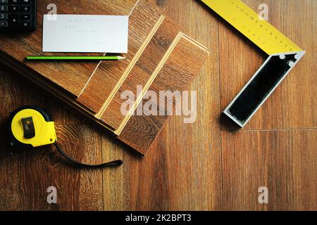 Laminat Dielen und Tools auf Holz- Hintergrund. Verschiedene Tischler Werkzeuge auf dem Laminat. Top View Stockfoto