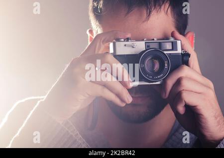 Ein Mann, der eine Retro-Kamera fährt Stockfoto