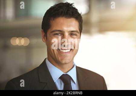 Das Geschäft läuft gut. Zugeschnittenes Porträt eines Geschäftsmannes, der in seinem Büro steht. Stockfoto