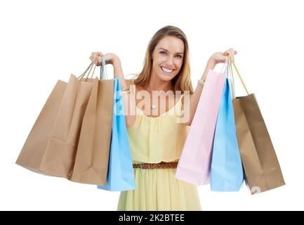 Ein gutes Gefühl bei diesen Einkäufen. Studioporträt einer lächelnden jungen Frau, die Einkaufstaschen trägt. Stockfoto