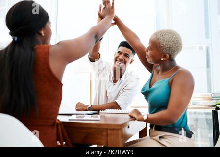 Sie haben die geheime Formel für ein gewinnendes Team erhalten. Aufnahme einer Gruppe von Geschäftsleuten, die sich bei einer Besprechung in einem modernen Büro gegenseitig fünf hohe Sterne geben. Stockfoto