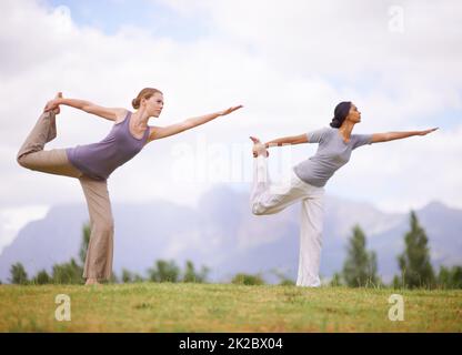 Sich um Körper und Geist kümmern. Frauen machen Yoga im Freien. Stockfoto