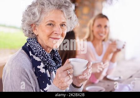 Tee belebt Sie. Aufnahme von drei Generationen der Frau der Frauen einer Familie, die draußen Tee trinkt. Stockfoto