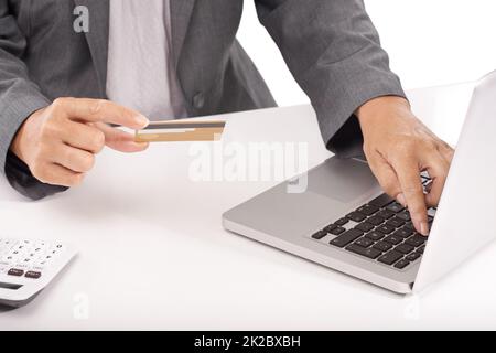 Mit dem Internet-Banking sparen Sie Zeit. Eine Nahaufnahme einer Geschäftsfrau, die ihre Kreditkarte hält, während sie an ihrem Laptop arbeitet. Stockfoto