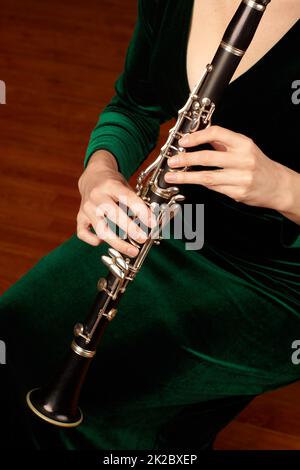 Das Wunder des Holzwindes. Ein zugeschnittenes Bild einer Frau, die eine Klarinette spielt. Stockfoto