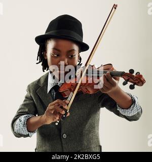Y. Ein junger afroamerikanischer Junge, der eine Geige spielt. Stockfoto