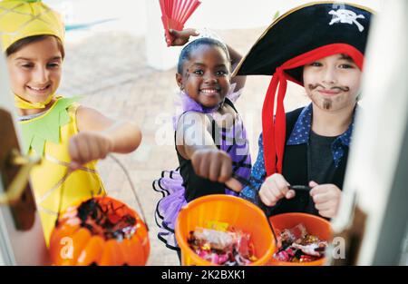 Candy Time. Aufnahme einer Gruppe von kleinen Kindern, die Trick-or-Treating machen. Stockfoto