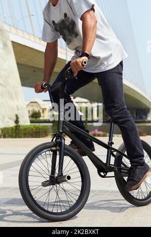 Führen Sie bis zu seinem besten Trick. Ein BMX-Fahrer macht Tricks in der Stadt. Stockfoto