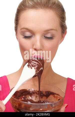 Delikatessen aus dem Leben genießen. Eine junge blonde Frau genießt eine Schüssel mit Schokoladenpudding. Stockfoto