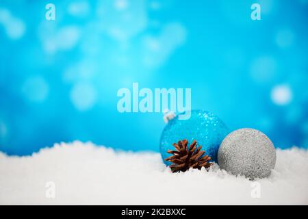 Weihnachten ist besser mit Glitzer. Eine Anordnung von Weihnachtsdekorationen auf einem funkelnden blauen Hintergrund. Stockfoto