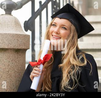 Träumen von ihrer perfekten Karriere. Inspirierter junger Absolvent nach dem Abschluss mit Diplom. Stockfoto