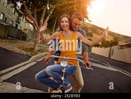 Genießen Sie eine romantische Fahrt durch die Straßen. Aufnahme eines glücklichen jungen Paares, das gemeinsam eine Fahrradtour macht. Stockfoto