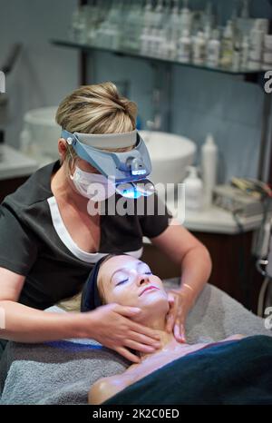 Eine Frau, die eine Gesichtsbehandlung in einer Klinik bekommt. Stockfoto