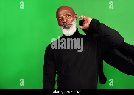 Ich bin es nie leid, sich zu verkleiden. Studioaufnahme eines älteren Mannes, der vor grünem Hintergrund posiert. Stockfoto