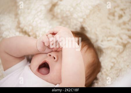 Es ist definitiv eine Mittagsschlaf-Zeit. Aufnahme eines entzückenden Babys, das gähnte. Stockfoto