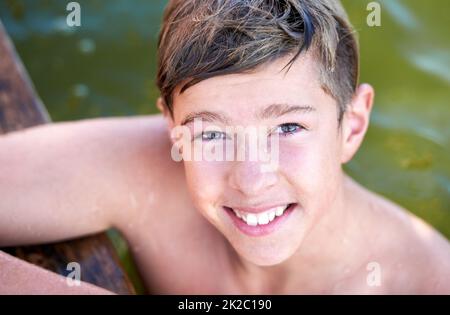 Einfache Freuden. Porträt eines Jungen im Teenageralter, der in einem See schwimmt. Stockfoto