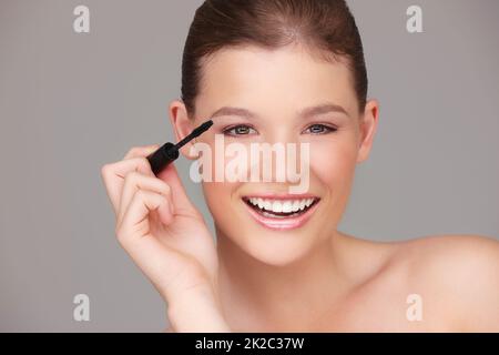 Sicherstellen, dass meine Augen hervorstechen. Studio Portrait einer schönen Frau, die Mascara anwendet. Stockfoto