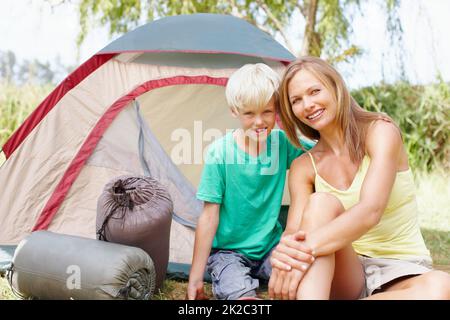 Mutter und Sohn campen. Portrait von Mutter und Sohn, die im Urlaub campen und Ihnen ein nettes Lächeln schenken. Stockfoto