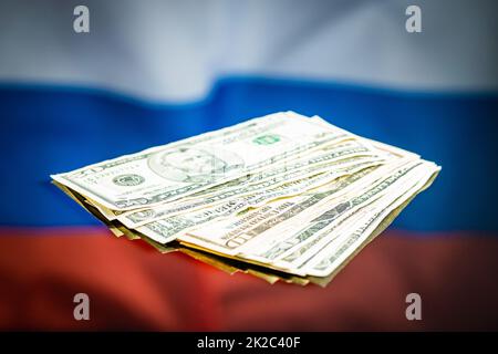 Dollar-Banknoten vor russischer Flagge. Papier in US-Währung. Stockfoto