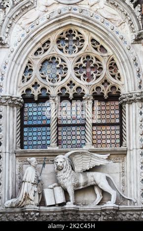 Venezianischer Löwe und Doge in einem Dom-Gebäude auf dem Markusplatz in Venedig, Italien. Venedigs Symbol der geflügelte Löwe Stockfoto