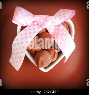 Gourmet Schokolade Trüffel für Valentinstag. Schokolade Süßigkeiten in Herzform Teller und Zierband serviert. Stockfoto