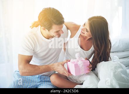 Ich habe eine kleine Überraschung für Sie bekommen. Aufnahme eines liebevollen Mannes, der seiner Frau ein Geschenk gab. Stockfoto