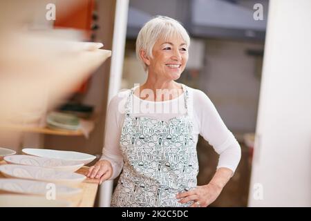 Die Kunst der Töpferei zu schätzen. Aufnahme einer älteren Frau, die in einer Werkstatt einen Keramiktopf macht. Stockfoto