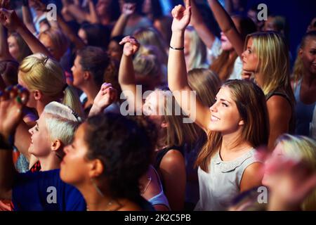 Eine Gruppe liebenswerter Fans, die zu ihrem Lieblingslied singen. Dieses Konzert wurde ausschließlich für diesen Fototermin mit 300 Modellen und 3 Live-Bands geschaffen. Alle Leute in diesem Fotoshooting sind Model-veröffentlicht. Stockfoto