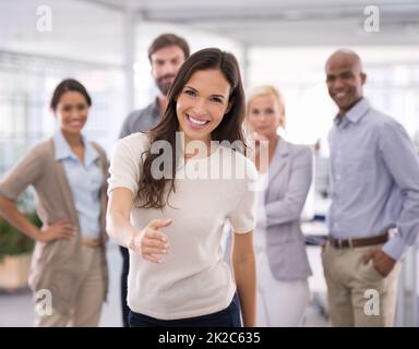 Willkommen, lassen Sie mich Sie dem Team vorstellen. Aufnahme einer attraktiven Geschäftsfrau mit ausgestreckten Händen zur Begrüßung. Stockfoto