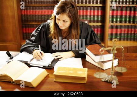Shes ein Experte in der Rechtswelt. Aufnahme einer jungen juristischen Fachkraft, die in einem Arbeitszimmer an ihrem Schreibtisch sitzt. Stockfoto