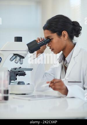 Erweiterung des wissenschaftlichen Wissens durch detaillierte Untersuchungen. Ausgeschnittene Aufnahme einer jungen Wissenschaftlerin, die in einem Labor arbeitet. Stockfoto