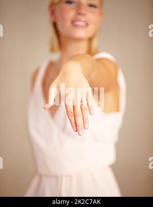 Ich habe ja gesagt. Ausgeschnittene Aufnahme einer jungen Frau, die ihren Verlobungsring zeigt. Stockfoto