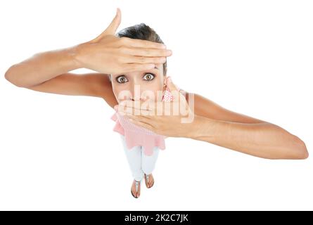 Jetzt siehst du mich, jetzt nicht. Studioportrait einer jungen Frau, die ihr Gesicht teilweise vor einem weißen Hintergrund bedeckt. Stockfoto