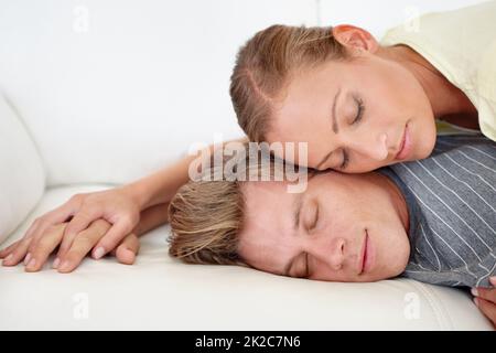 Ein paar Schläfchen. Eine Frau, die auf dem Rücken ihres mannes liegt. Stockfoto