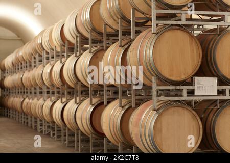 Massenproduzierender Wein. Gestapelte Fässer Wein in einer Weinbrennerei. Stockfoto