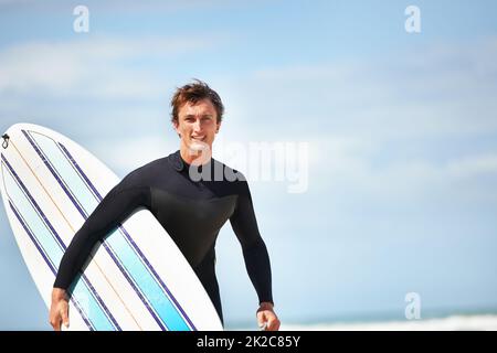 Es ist nur ich und mein Surfbrett. Porträt eines jungen Surfers am Strand an einem sonnigen Tag. Stockfoto